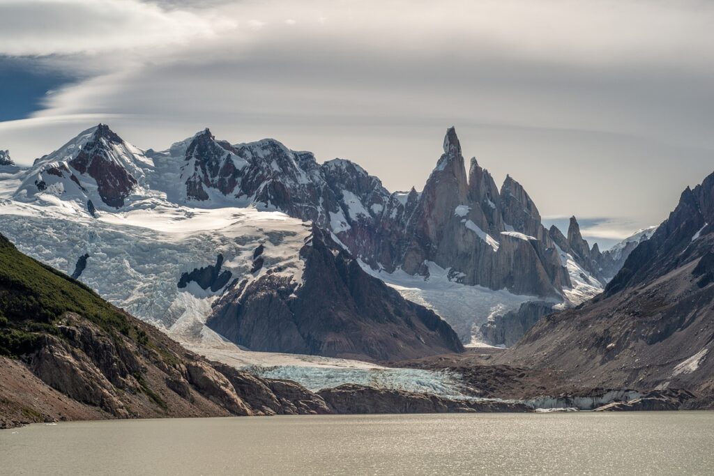 a body of water with snow on the mountains